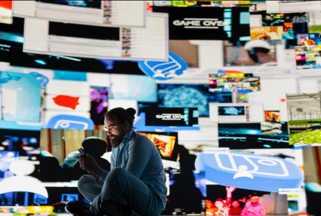 Молодой человек в темноте, освещённый экраном телефона, вокруг давящее пространство и пустота